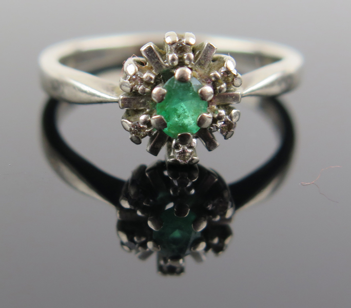 Ring 18 karat vitguld med 1 facettslipad smaragd om 0,2 carat och 6 åttkantslipade diamanter om totalt 0,06 carat enligt gravyr, vikt 4,2 gram, _19545a_lg.jpeg