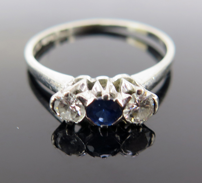 Ring, 18 karat vitguld med 2 briljantslipade diamanter om totalt cirka 0,2 carat samt 1 facettslipad safir, stämplad CG Hallberg Stockholm, innerdiameter 17 mm, vikt 2,4 gram