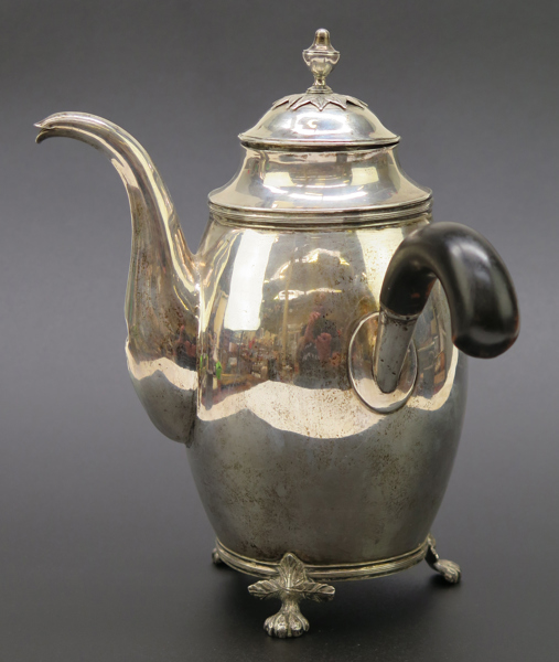 Kaffekanna, silver med svärtat träskaft, empire, 1800-talets 1 hälft, tunnformad, slät på 3 bladhölstrade lejontassar, stämplad Otto Magnus Krook Nyköping 1820, h 21 cm, vikt 420 gram, bucklor