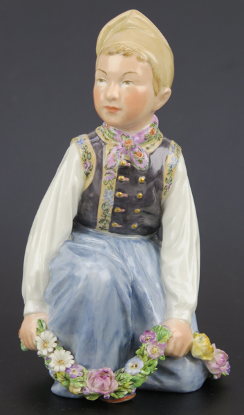 Hansen, Carl Martin för Royal Copenhagen, figurin, porslin, Amagerpojke ur serien Danmarks Børn, så kallad Juliane Marie, modellnummer 12414, utförd 1906-25, h 15 cm, någon obetydlig nagg