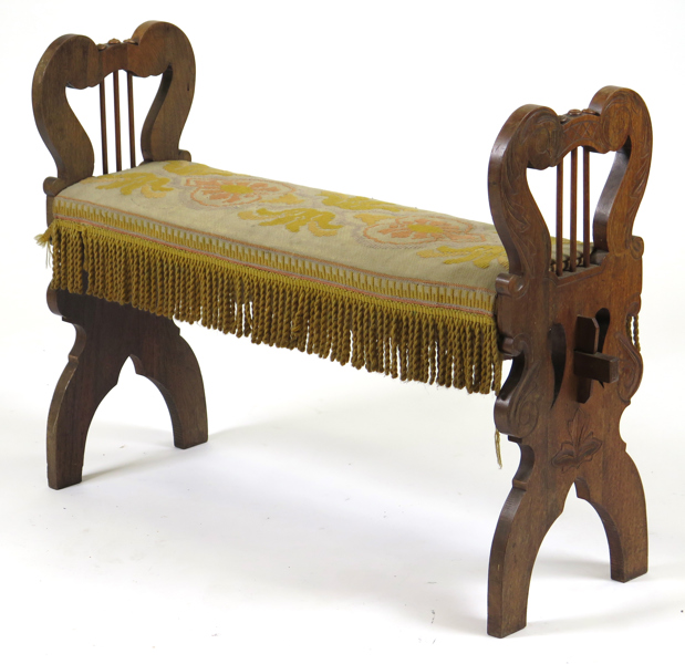 Pianobankett, skuren och bonad ek med broderad sits, 1800-talets slut, lyrgavlar, längd 95 cm