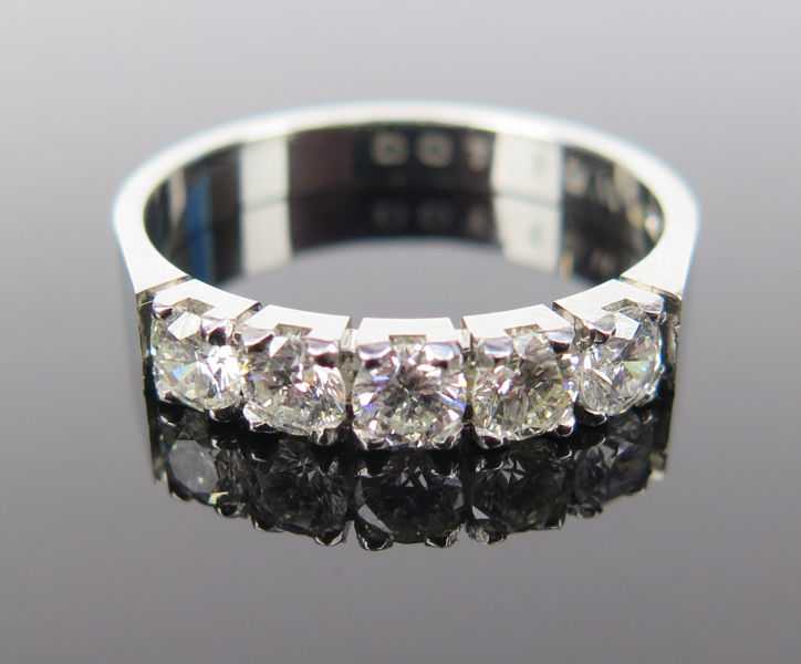 Ring, 18 karat vitguld med 5 briljantslipade diamanter om totalt 1,0 carat enligt gravyr, svenska stämplar, innerdiameter 17 mm, vikt 4,3 gram, framstår oanvänd