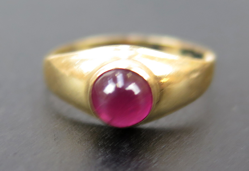 Ring, 18 karat rödguld med cabochonslipad rubin, otydliga svenska stämplar, innerdiameter 14 mm, vikt 1 gram