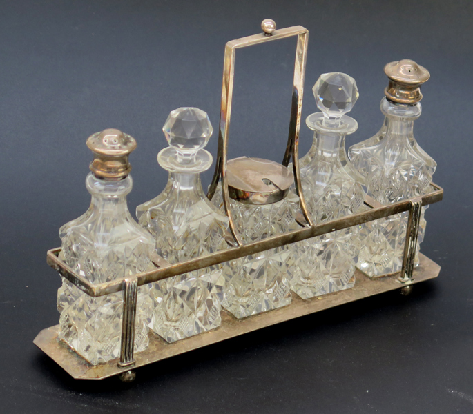 Bordssurtout, nysilver med slipade glasflaskor, 1900-talets början, salt-och pepparströare, olje- och vinägerkanna samt senapsburk med lock, stämplad Axel Gabriel Dufva Stockholm, l